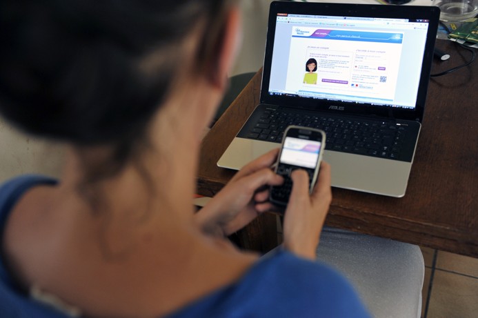 Femme qui se connecte à son compte ameli sur smartphone et ordinateur.