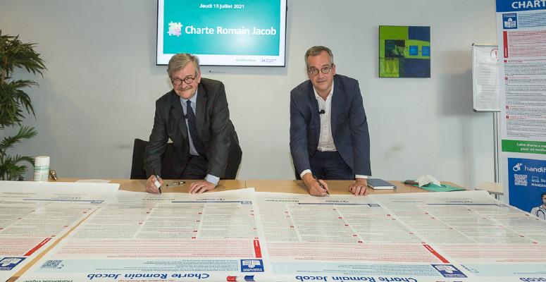 Pascal Jacob, président de l’association Handidactique et Thomas Fatôme, directeur général de l’Assurance Maladie, signent la charte Romain Jacob, le 30 juillet 2021