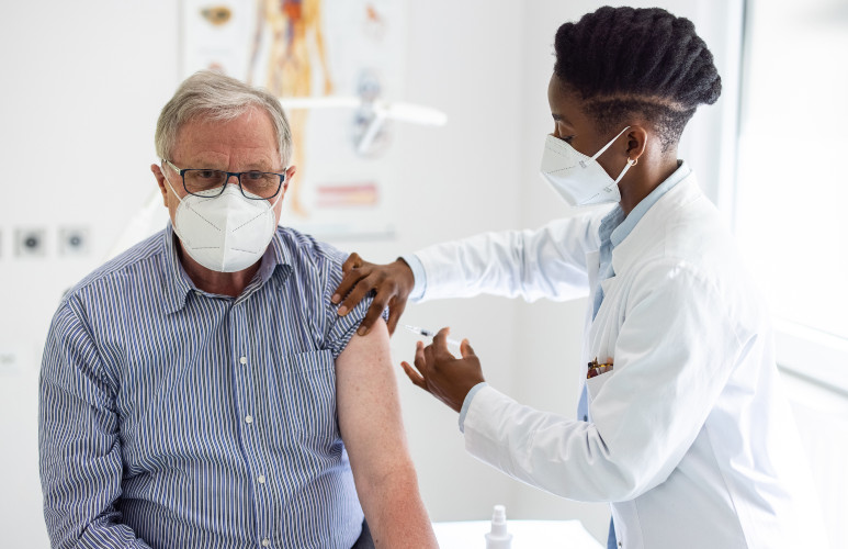 Une soignante administre un vaccin anti-Covid à un homme âgé dans un cabinet médical