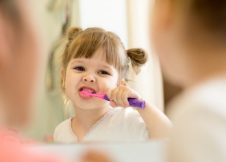 Photo d'une petite fille se brossant les dents