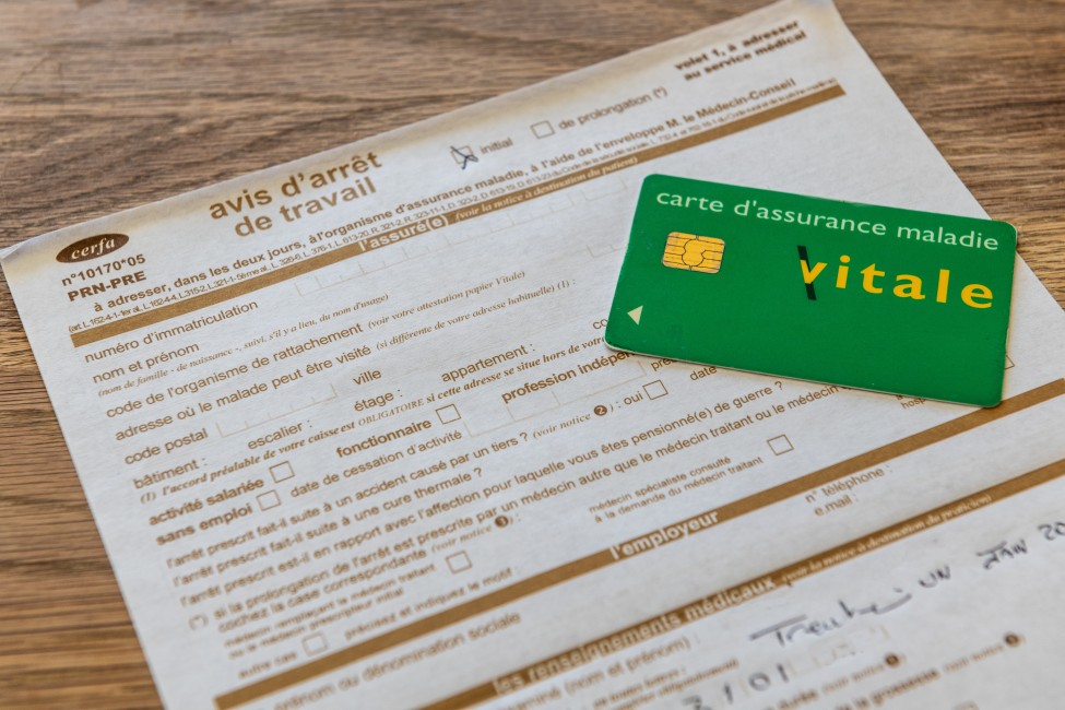 Un avis d'arrêt de travail et une carte Vitale