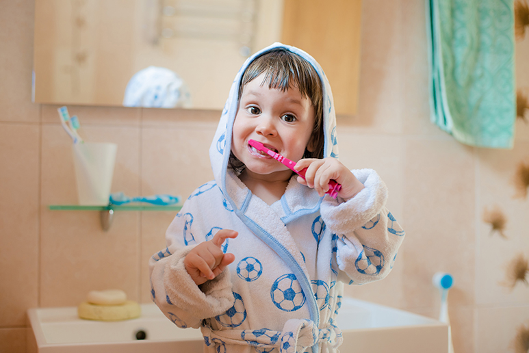 Photo représentant un petit enfant se brossant les dents.