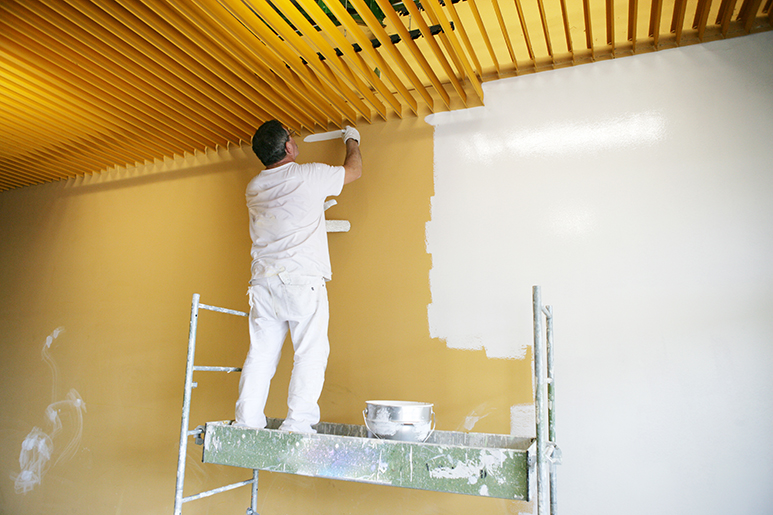 Photo d'un peintre en bâtiment sur un échaffaudage