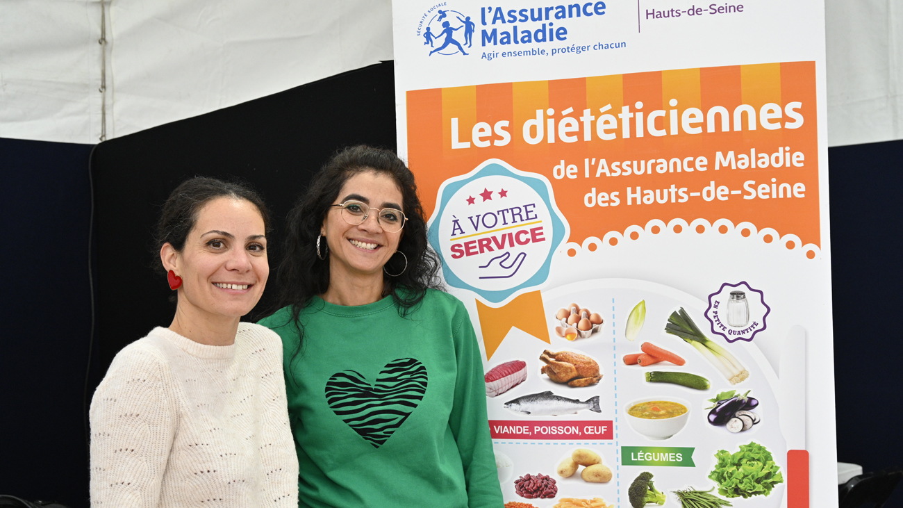 Consultations diététiques - 2 diététiciennes souriantes devant un stand d’information