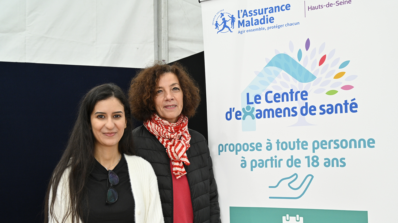 2 conseillères en santé souriantes devant un stand d’information 