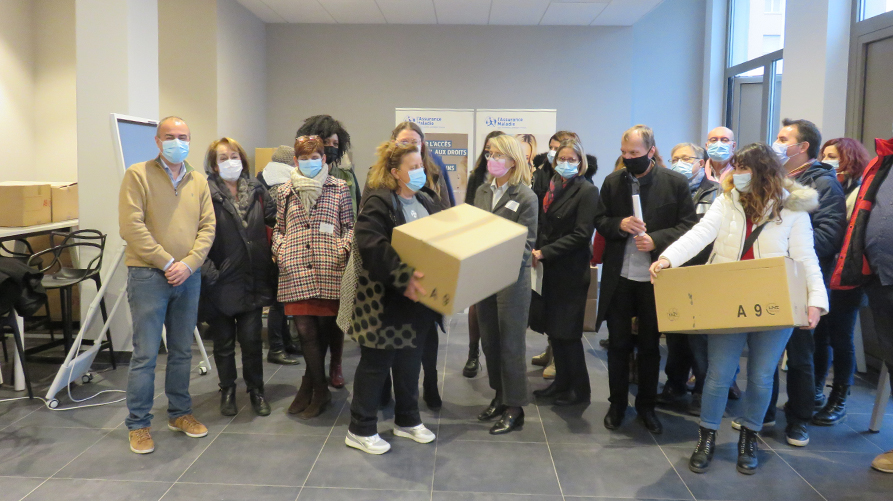 Photographie des partenaires et représentants de la CPAM lors de la distribution de kits d'hygiène au siège de la CPAM de Moselle.