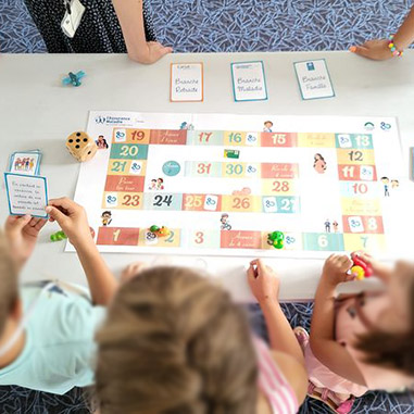 Journée des enfants organisée à la CPAM de la Sarthe : un groupe d'enfants joue à un jeu sur le thème des missions de la Sécurité sociale
