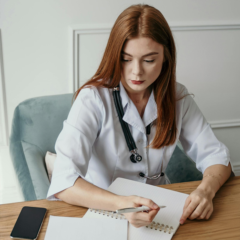 Photo d'une femme docteur signant un document. Crédits photo Pexel