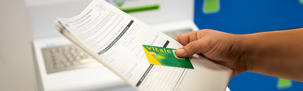 Photo d'une personne avec une feuille de soins et une carte Vitale. Crédits photo : A.Detienne/ Capa