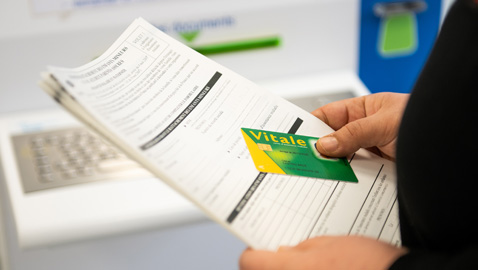 Photo d'une personne avec une feuille de soins et une carte Vitale. Crédits photo : A.Detienne/ Capa Pictures