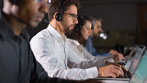 Téléconseillères et téléconseillers en activités, équipés d'un casque et d'un ordinateur