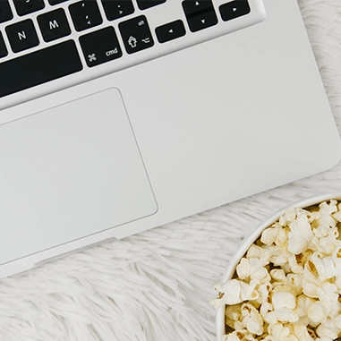 Un ordinateur avec du pop-corn en bas dans le coin
