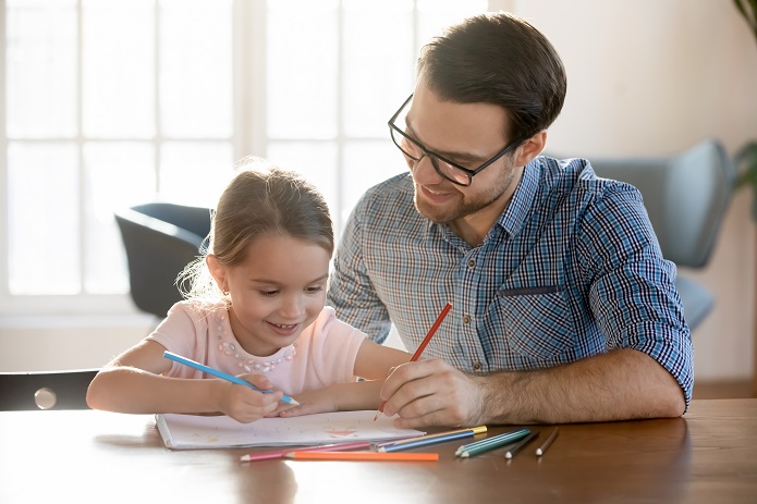 Un père et sa fille faisant des activités à la maison