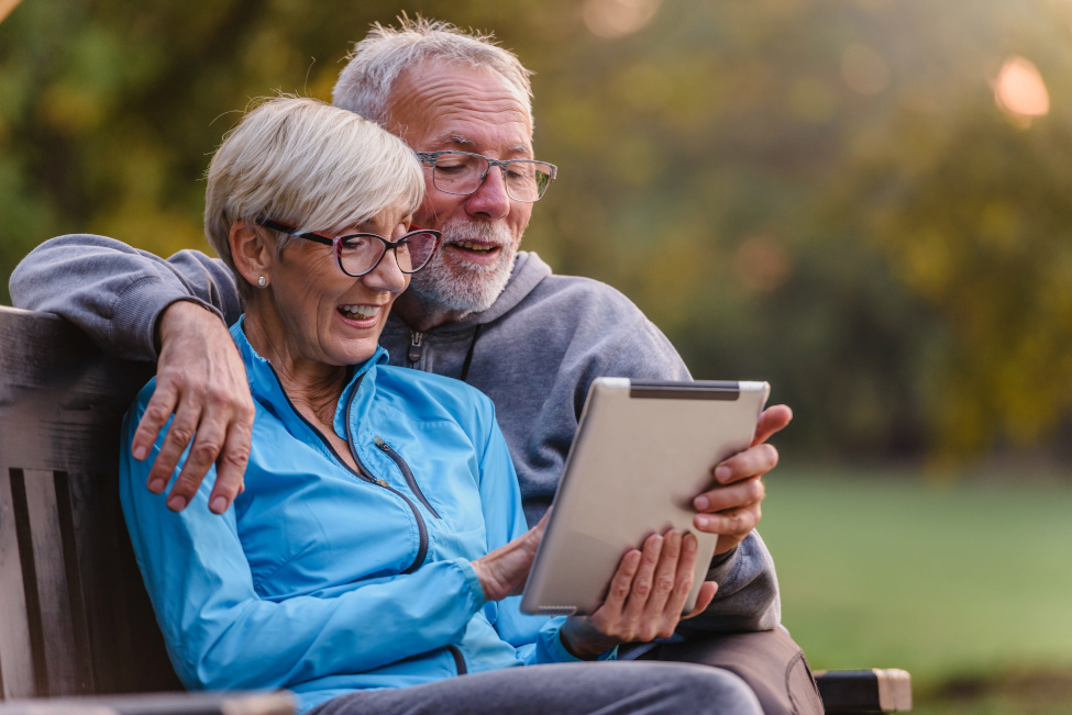 Un couple de personnes âgées utilisant les services en ligne sur une tablette